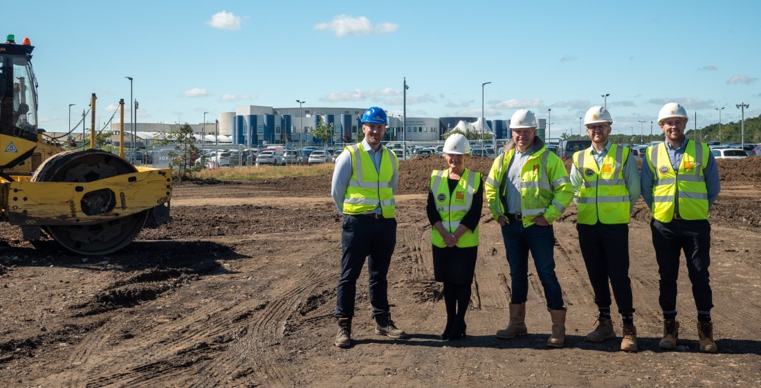 Four people standing on a construction site at Northumbria Specialist Emergency Care Hospital in Cramlington.
