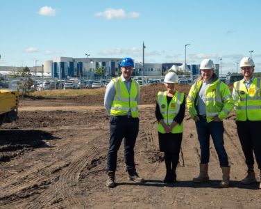 Four people standing on a construction site at Northumbria Specialist Emergency Care Hospital in Cramlington.